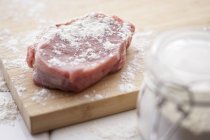 Pezzo di maiale crudo spolverato nella farina — Foto stock