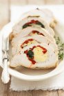 Turkey breast stuffed with egg, spinach and red peppers  on white plate with fork — Stock Photo
