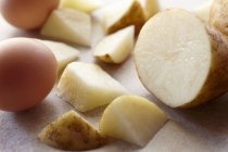 Frische geschnittene Kartoffeln und rohe Eier — Stockfoto