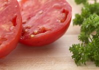 Tomates et persil frais coupés en deux — Photo de stock