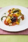 Baked peppers with garlic on white plate over towel — Stock Photo