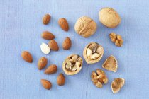 Walnuts and almonds on blue — Stock Photo
