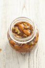 Walnuts and almonds in honey — Stock Photo