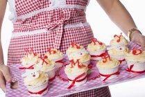 Mulher segurando cupcakes na bandeja — Fotografia de Stock