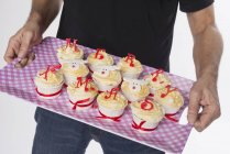 Homem segurando cupcakes na bandeja — Fotografia de Stock