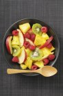 Salada de frutas com kiwi e framboesas em tigela — Fotografia de Stock