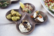 A plate of nibbles with houmous and olives — Stock Photo