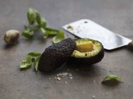 Halbierte Avocado mit frischem Basilikum — Stockfoto