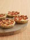 Tomato tartlets on a wooden board — Stock Photo