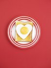 Toast topped with fried heart-shaped egg — Stock Photo