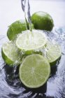 Limes avec éclaboussures d'eau — Photo de stock