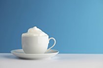 Vue rapprochée de la mousse de lait en tasse blanche — Photo de stock