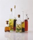 Nature morte avec diverses huiles aromatisées en bouteilles — Photo de stock