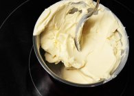 Vista de cerca de la mantequilla derretida con cuchara en un tazón - foto de stock