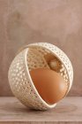 Коричневое яйцо в декоративной чаше — стоковое фото