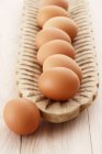 Ovos castanhos em prato de madeira — Fotografia de Stock