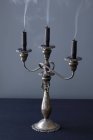 Vue rapprochée d'un chandelier avec trois bougies sombres soufflées — Photo de stock
