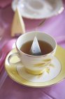 Tasse Tee mit dreieckigem Teebeutel — Stockfoto