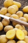 Batatas inteiras e cortadas pela metade — Fotografia de Stock