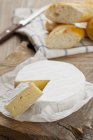 Camembert mit Scheibe in Papier — Stockfoto