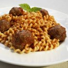 Meatballs over cavatappi pasta — Stock Photo