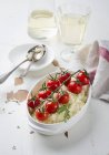 Risotto with cocktail tomatoes, white wine over wooden surface — Stock Photo