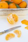 Clementina pelada con cuchillo - foto de stock