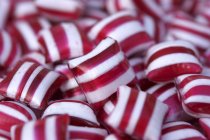 Vista de cerca de caramelos de menta a rayas rojas y blancas - foto de stock