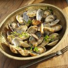 Closeup view of little neck clams with fresh herbs in copper bowl — Stock Photo