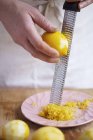 Chef Grating lemon peel — Stock Photo