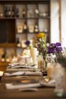 Ein gedeckter Tisch mit bunten Blumen in einem Restaurant — Stockfoto