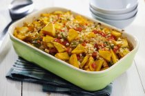 Squash Pepper Casserole and Ingredients in green dish over towel — Stock Photo
