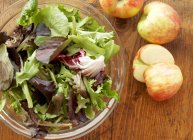 Миска з листя салату і яблук — стокове фото
