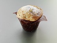 Muffin in baking parchment — Stock Photo