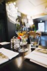 Primo piano vista di un bicchiere di vino con frutta su una tavola apparecchiata in ristorante — Foto stock