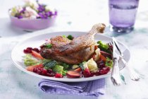 Duck leg on savoy cabbage with cranberries — Stock Photo