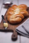 Vista close-up de pão entrançado em tábua de madeira — Fotografia de Stock