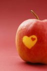 Closeup view of red apple with hearts on skin — Stock Photo