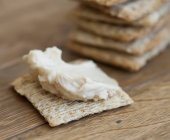 Cracker with houmous on wooden surface — Stock Photo