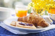 Frühstück mit Croissant auf Teller — Stockfoto