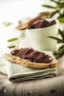 Crostino con crema di olive Toast mit Olivenaufstrich auf Handtuch über textiler Oberfläche — Stockfoto
