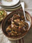 Closeup view of Coq au Vin with spoon in ceramic dish — Stock Photo