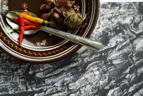 Chilischoten und Knoblauch in Schüssel mit Löffel — Stockfoto
