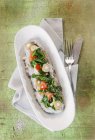 Polenta di grano saraceno con spinaci su piatto bianco sopra asciugamano con forchetta e coltello — Foto stock