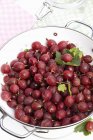 Red gooseberries in colander — Stock Photo