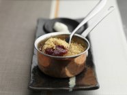 Closeup view of apple and berry crumble with spoon in pot — Stock Photo