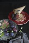 Prugne e fiori su piatti — Foto stock