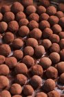 Vista de cerca de trufas de mazapán en polvo de chocolate - foto de stock