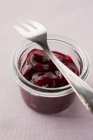 Cherry jam in glass with fork — Stock Photo