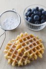Waffles with icing sugar and fresh blueberries — Stock Photo